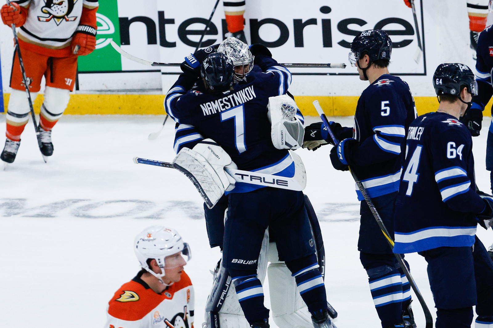 Apr 16, 2025; Winnipeg, Manitoba, CAN; Winnipeg Jets goalie Connor Hellebuyck (37) is congratulated by his team mates on his win against the Anaheim Ducks at the end of the overtime period at Canada Life Centre. Mandatory Credit: Terrence Lee-Imagn Images