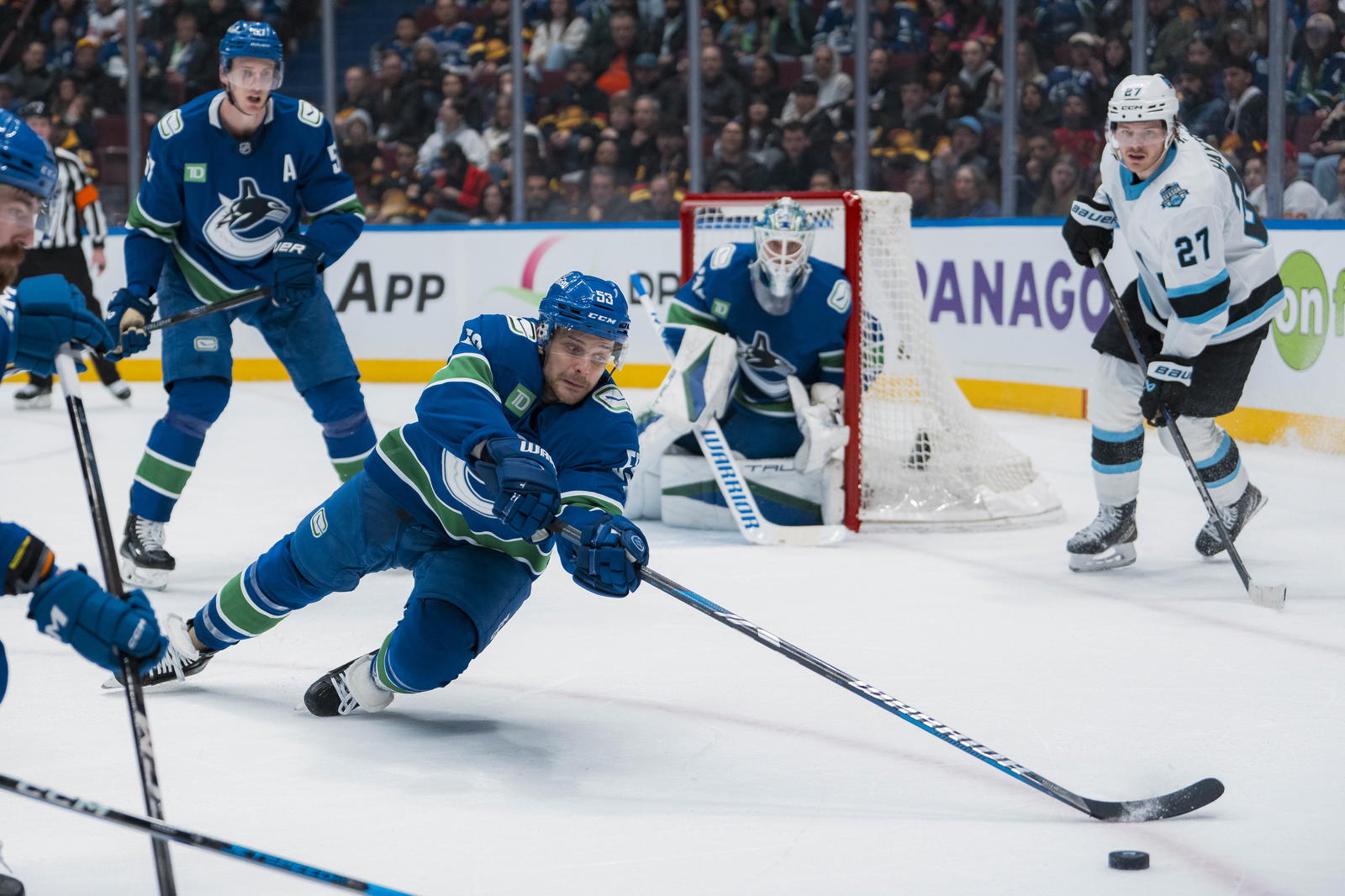 Mar 16, 2025; Vancouver, British Columbia, CAN; Vancouver Canucks forward Teddy Blueger (53) dives for a loose puck against Utah Hockey Club in the second period at Rogers Arena. Mandatory Credit: Bob Frid-Imagn Images