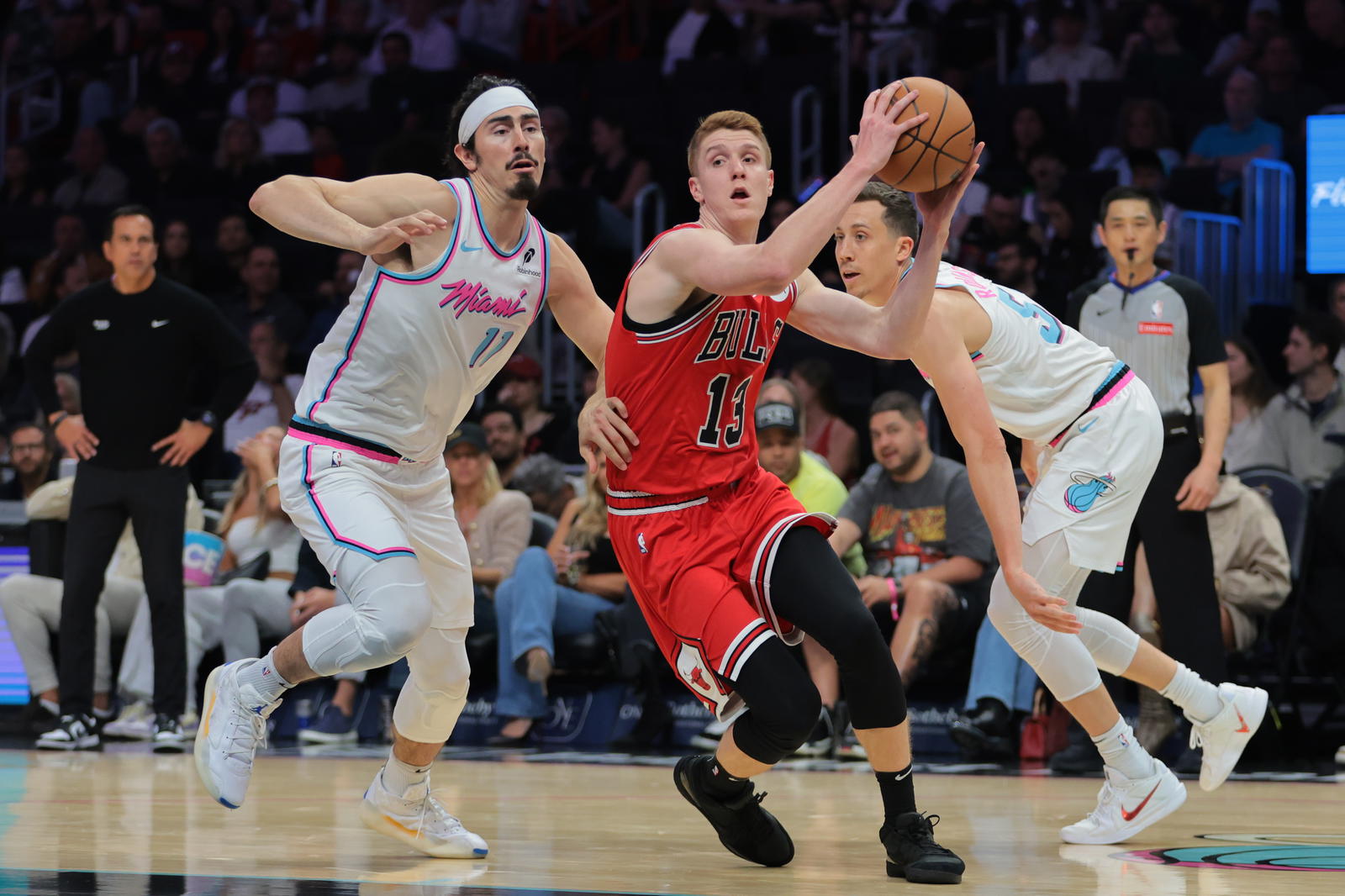 Mar 8, 2025; Miami, Florida, USA; Chicago Bulls guard Kevin Huerter (13) drives to the basket past Miami Heat guard Jaime Jaquez Jr. (11) and forward Duncan Robinson (55) during the first quarter at Kaseya Center. Mandatory Credit: Sam Navarro-Imagn Images