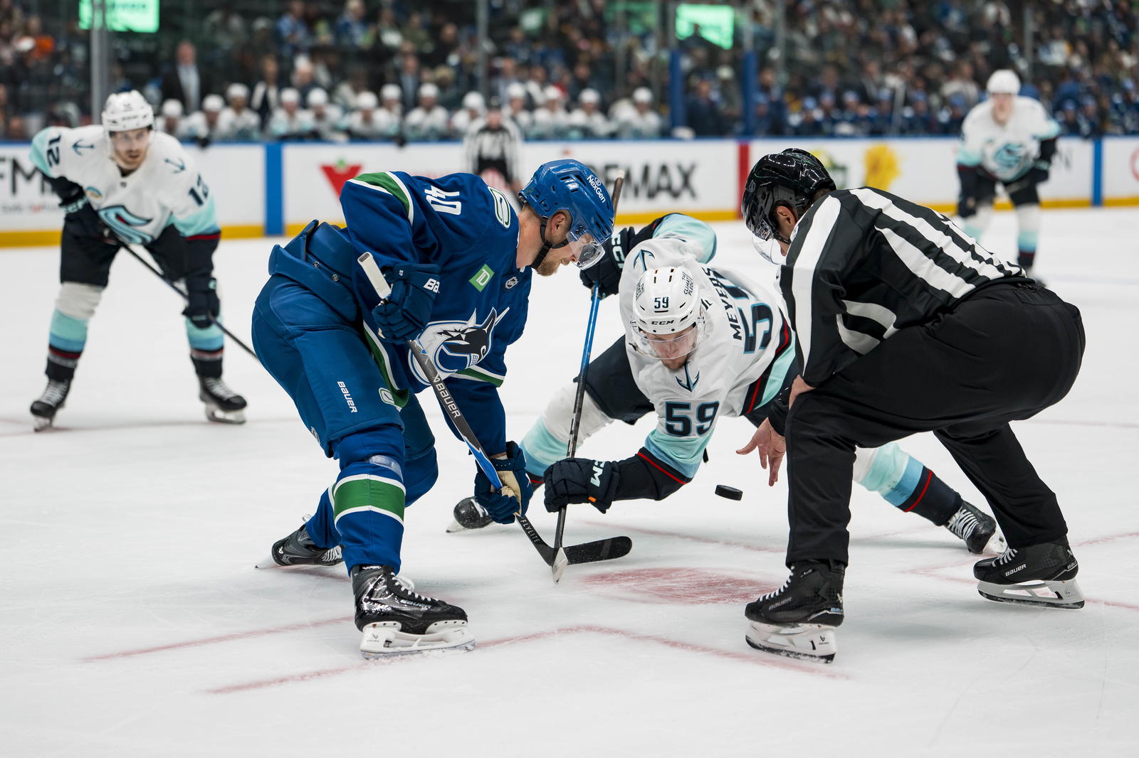 Sep 26, 2025; Vancouver, British Columbia, CAN; Vancouver Canucks forward Elias Pettersson (40) faces off against Seattle Kraken forward Ben Meyers (59) in the second period at Rogers Arena. Mandatory Credit: Bob Frid-Imagn Images