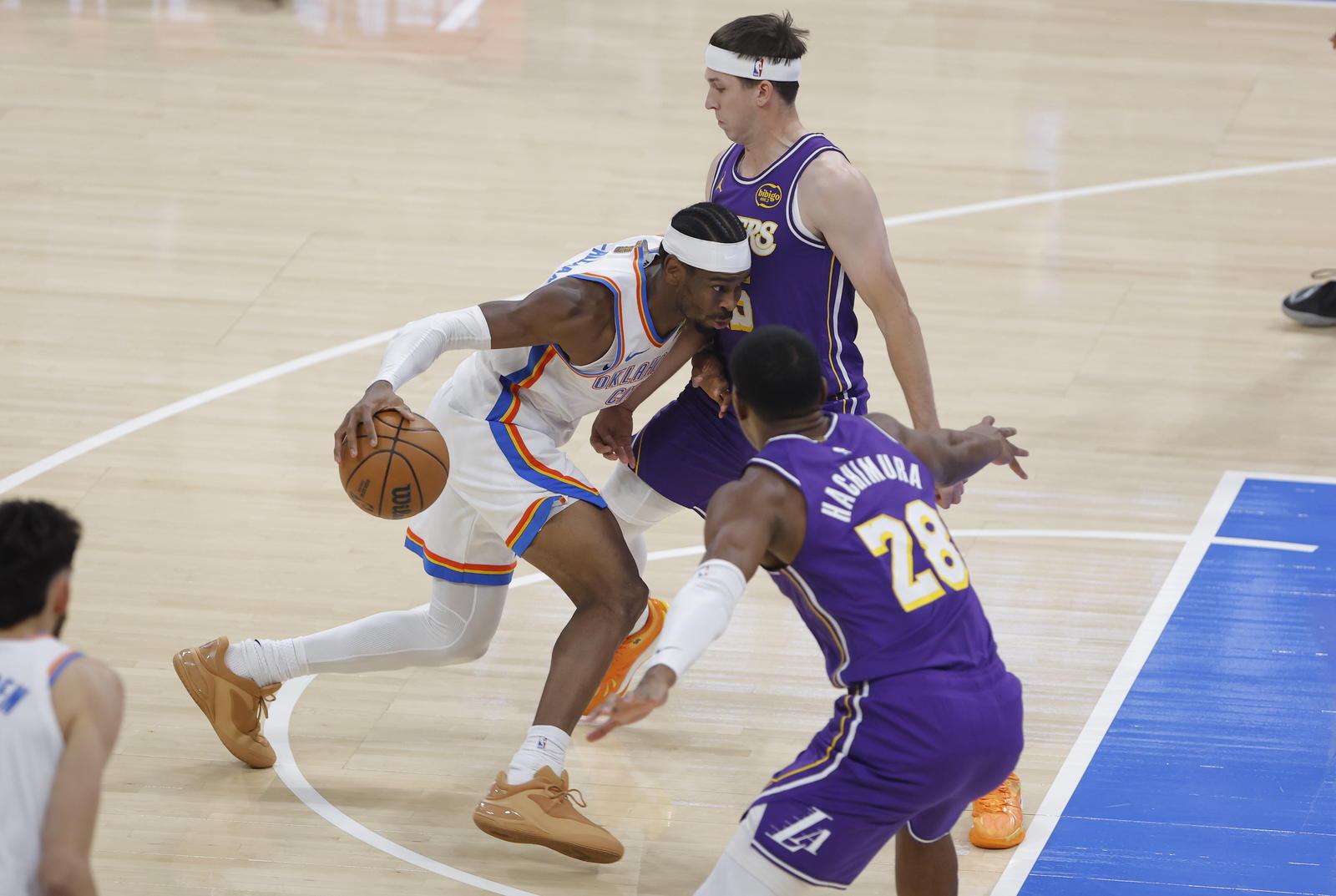 Oklahoma City Thunder guard Shai Gilgeous-Alexander (2) drives to the basket between Los Angeles Lakers forward Rui Hachimura (28) and guard Austin Reaves (15) during the first quarter at Paycom Center.&nbsp;Alonzo Adams-Imagn Images