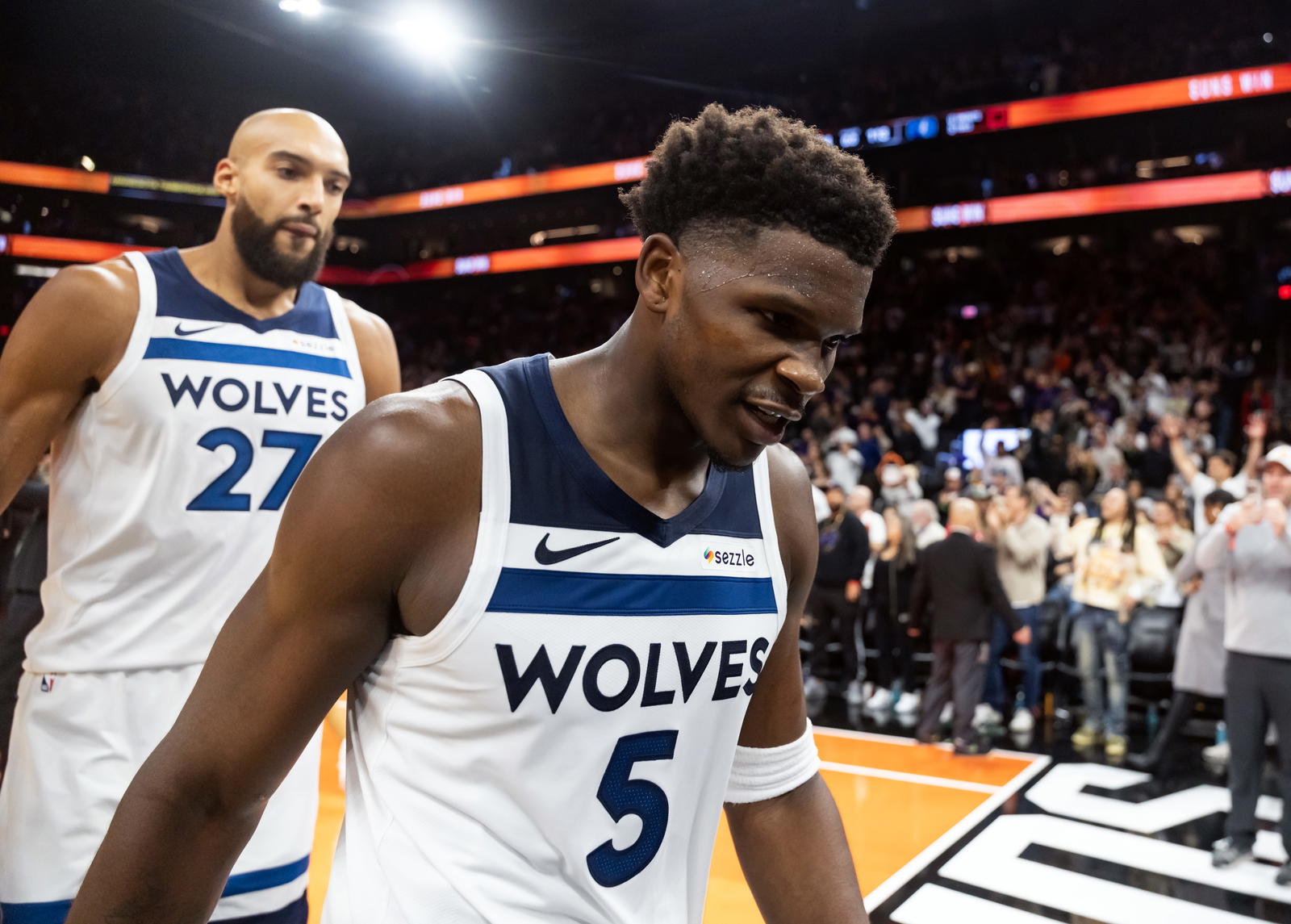 Minnesota Timberwolves guard Anthony Edwards (5) and center Rudy Gobert (27) react as they walk off the court after losing to the Phoenix Suns in the second half of an NBA Cup game at Mortgage Matchup Center. Mark J. Rebilas-Imagn Images