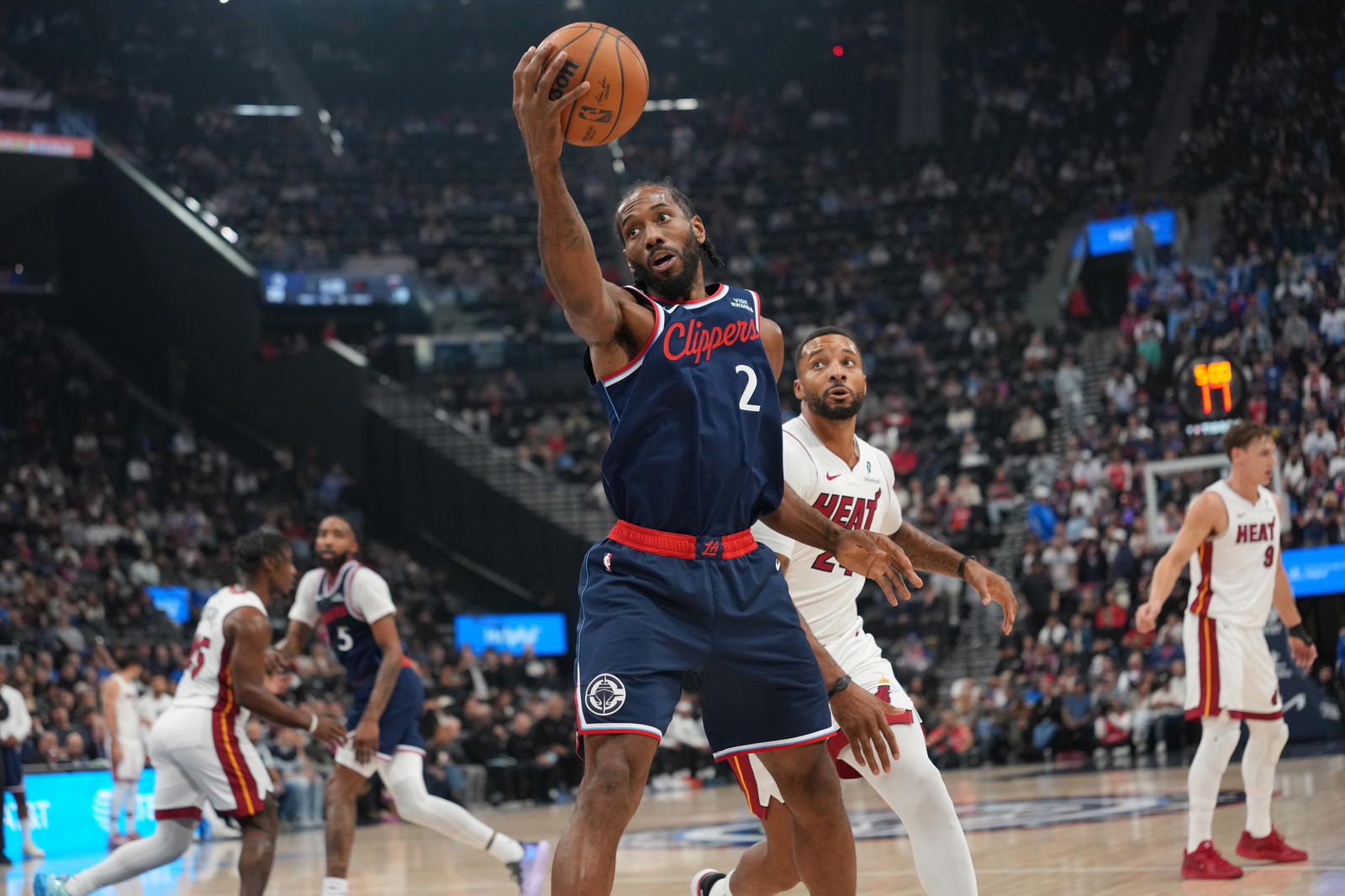 LA Clippers forward Kawhi Leonard (2) reaches for the ball against Miami Heat guard Norman Powell (24) in the first half at Intuit Dome. Kirby Lee-Imagn Images