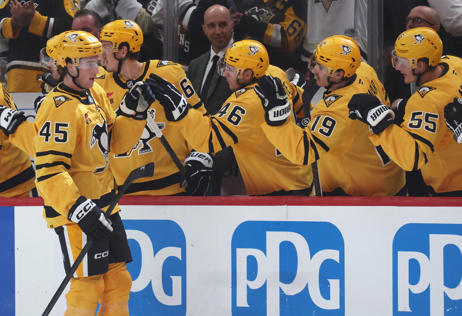 Oct 9, 2025; Pittsburgh, Pennsylvania, USA; Pittsburgh Penguins defenseman Harrison Brunicke (45) celebrates his first NHL goal with the Penguins bench against the New York Islanders during the second period at PPG Paints Arena. Mandatory Credit: Charles LeClaire-Imagn Images