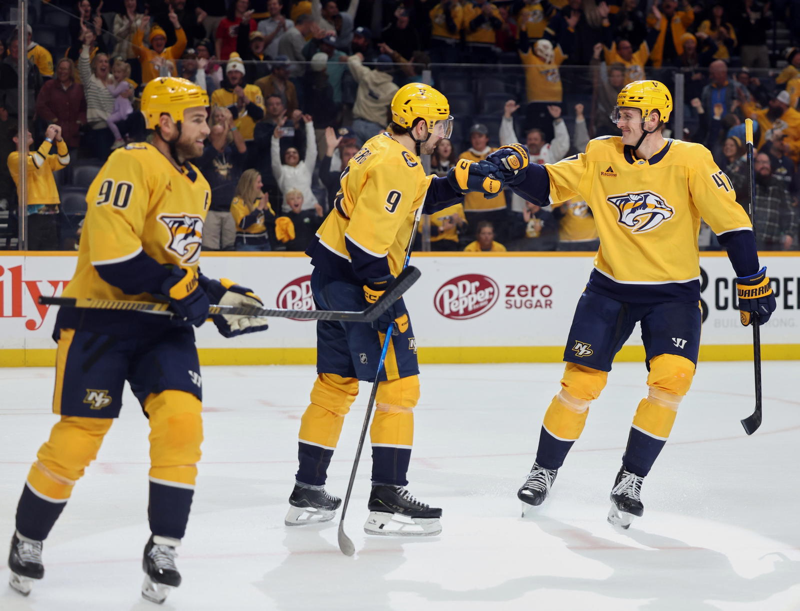 Nov 1, 2025; Nashville, Tennessee, USA; Nashville Predators left wing Filip Forsberg (9), right wing Michael McCarron (47) and center Ryan O'Reilly (90) celebrate an empty net goal scored against the Calgary Flames during the third period at Bridgestone Arena. Alan Poizner-Imagn Images