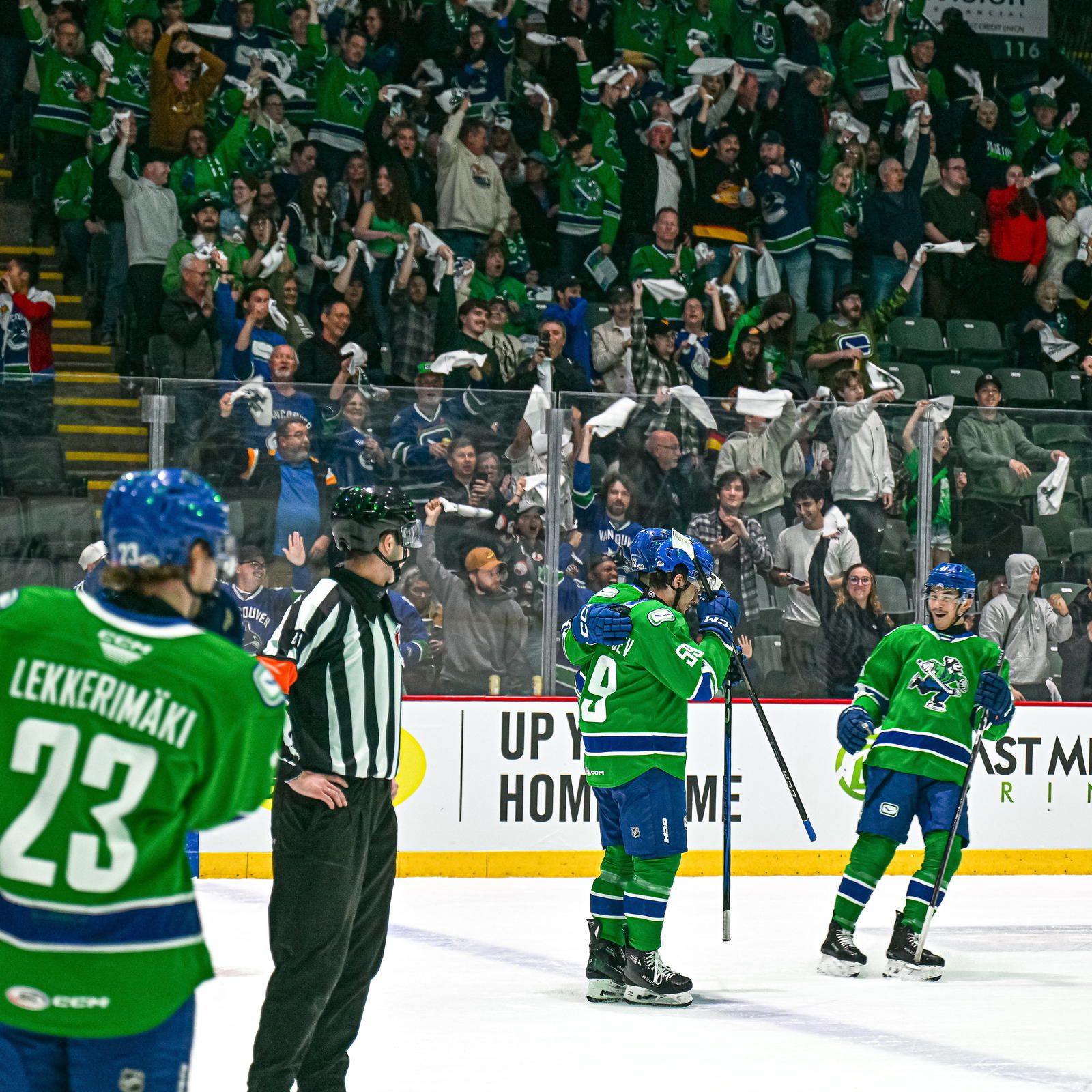 Abbotsford Canucks’ Kirill Kudryavstev (59), Max Sasson (63), and Akito Hirose (41) celebrate a goal. (Photo by @abbycanucks/X) 