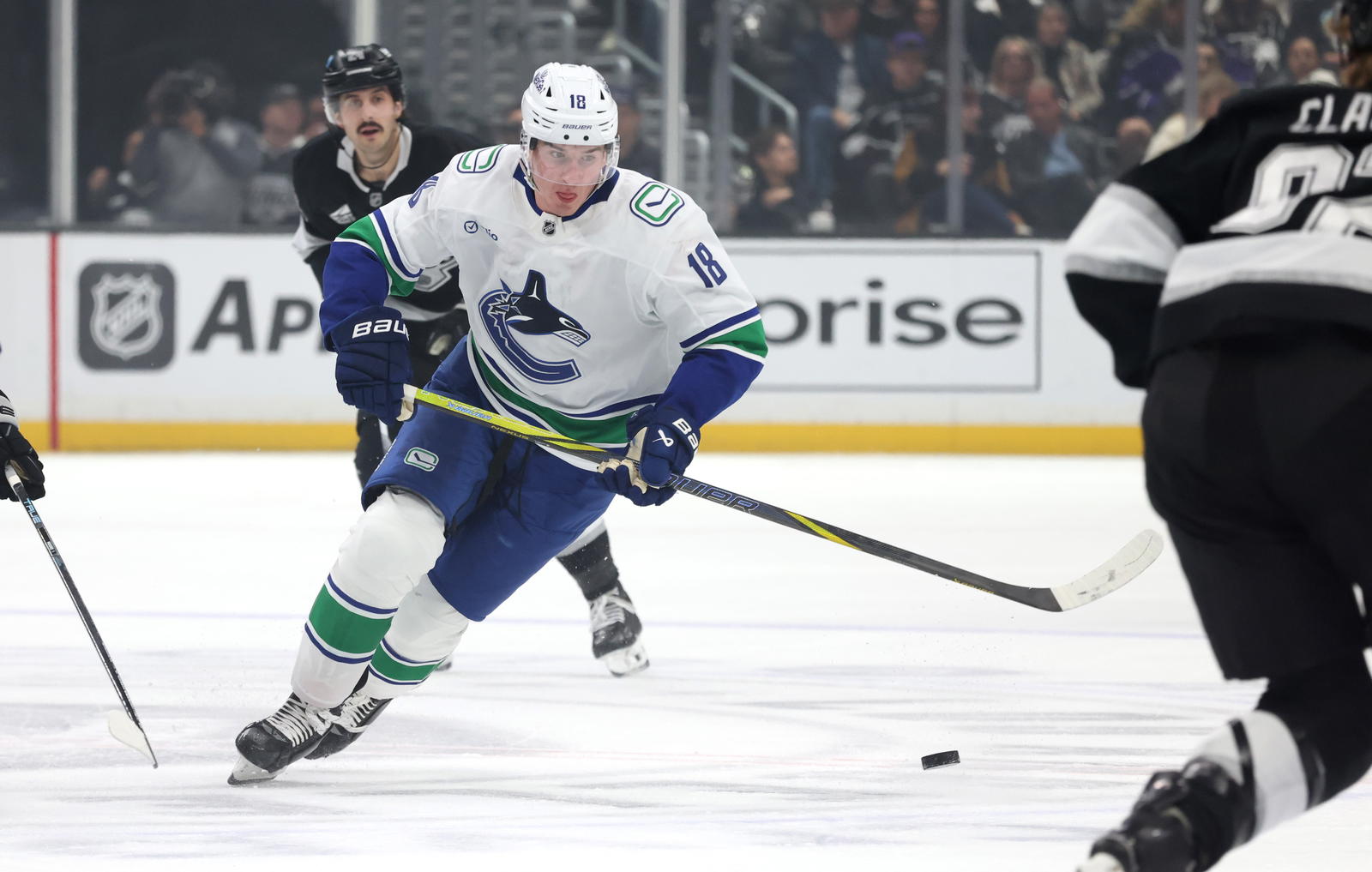 Feb 26, 2025; Los Angeles, California, USA; Vancouver Canucks left wing Drew O'Connor (18) skates with the puck during the first period against the Los Angeles Kings at Crypto.com Arena. Mandatory Credit: Jason Parkhurst-Imagn Images
