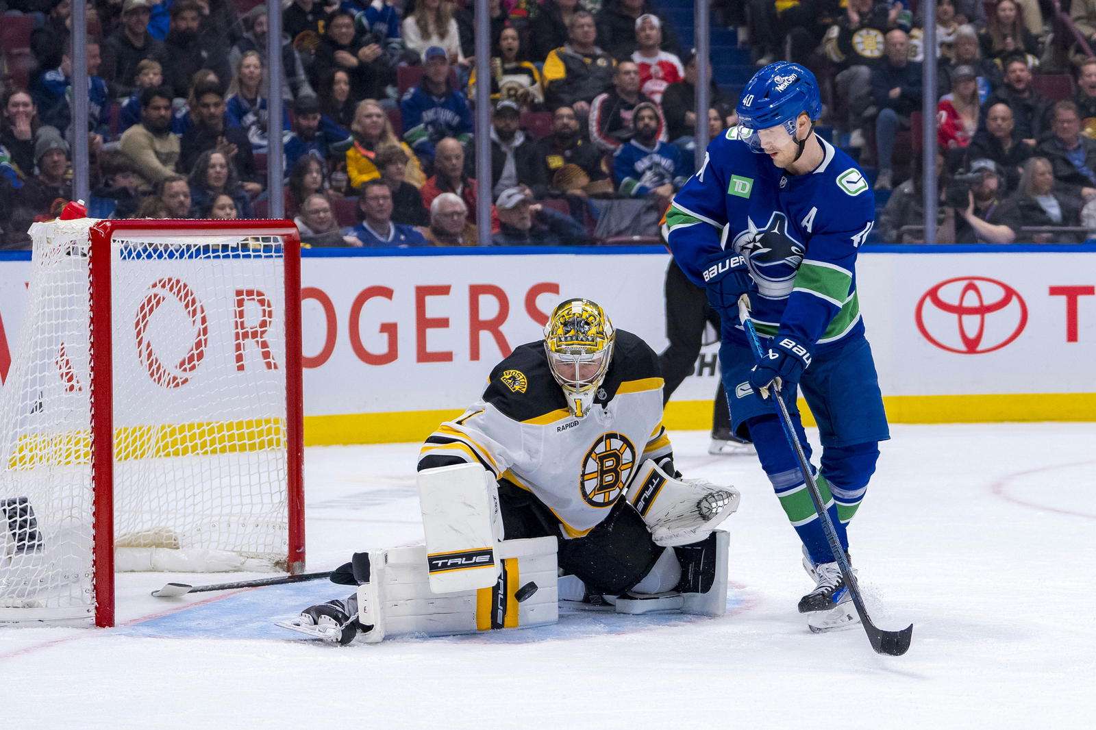 Dec 14, 2024; Vancouver, British Columbia, CAN; Boston Bruins goalie Jeremy Swayman (1) makes a save as Vancouver Canucks forward Elias Pettersson (40) looks for the rebound during the second period at Rogers Arena. Mandatory Credit: Bob Frid-Imagn Images