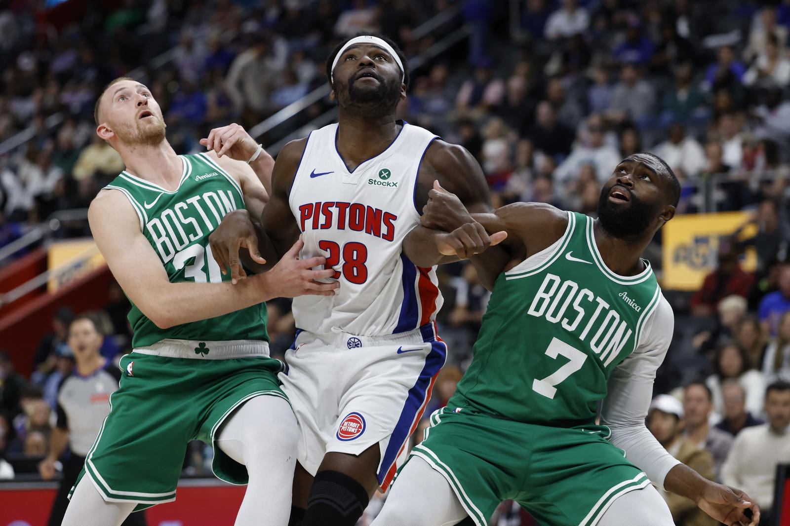 Oct 26, 2025; Detroit, Michigan, USA; Boston Celtics forward Sam Hauser (30) Detroit Pistons forward Isaiah Stewart (28) and guard Jaylen Brown (7) look for the. Rebound in the second half at Little Caesars Arena. (Rick Osentoski/Imagn Images)