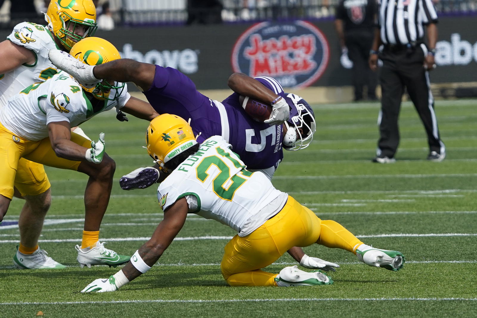 Sep 13, 2025; Evanston, Illinois, USA; Oregon Ducks defensive back Aaron Flowers (21) tackles Northwestern Wildcats running back Caleb Komolafe (5) during the first half at Northwestern Medicine Field at Martin Stadium. Mandatory Credit: David Banks-Imagn Image