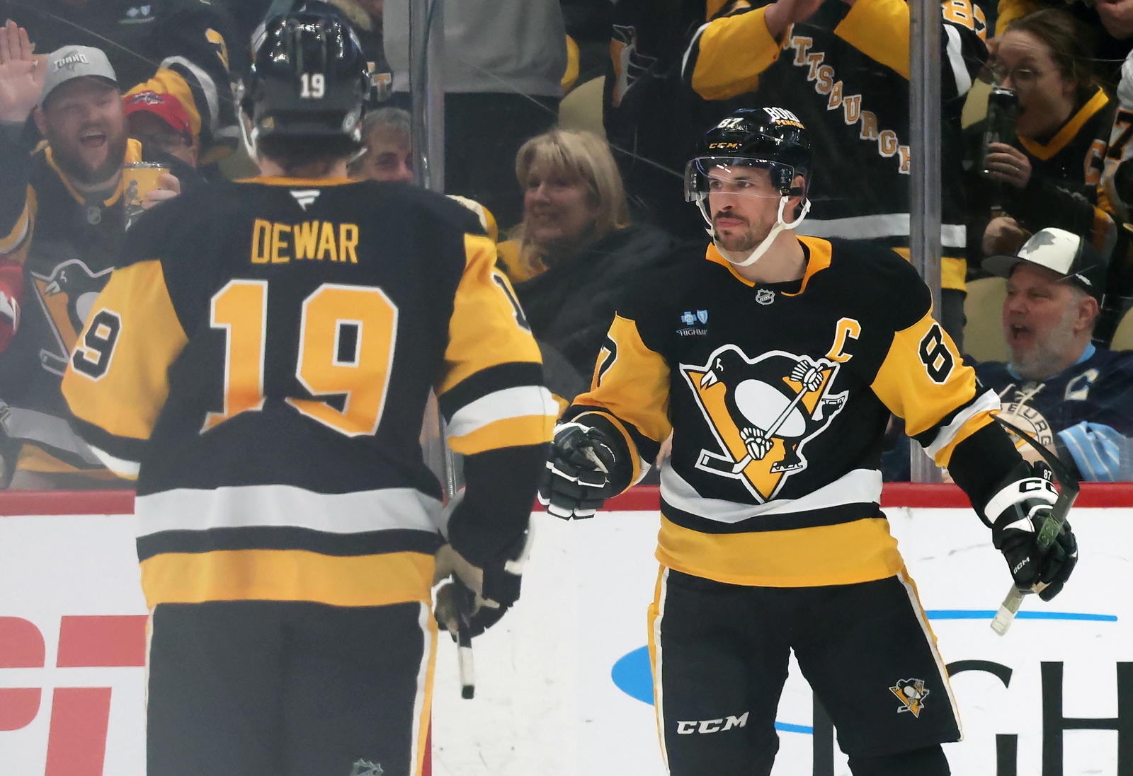 Apr 17, 2025; Pittsburgh, Pennsylvania, USA; Pittsburgh Penguins center Sidney Crosby (87) reacts with center Connor Dewar (19) after Crosby scored a goal against the Washington Capitals during the second period at PPG Paints Arena. Mandatory Credit: Charles LeClaire-Imagn Images