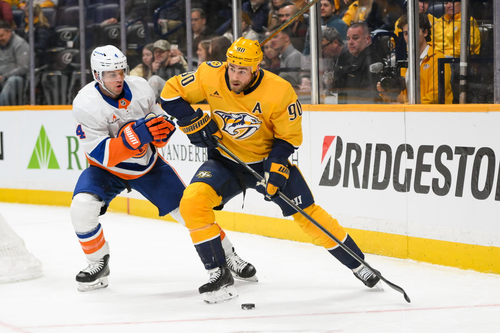 Apr 8, 2025; Nashville, Tennessee, USA; Nashville Predators center Ryan O'Reilly (90) skates behind the net against the New York Islanders during the third period at Bridgestone Arena. Mandatory Credit: Steve Roberts-Imagn Images