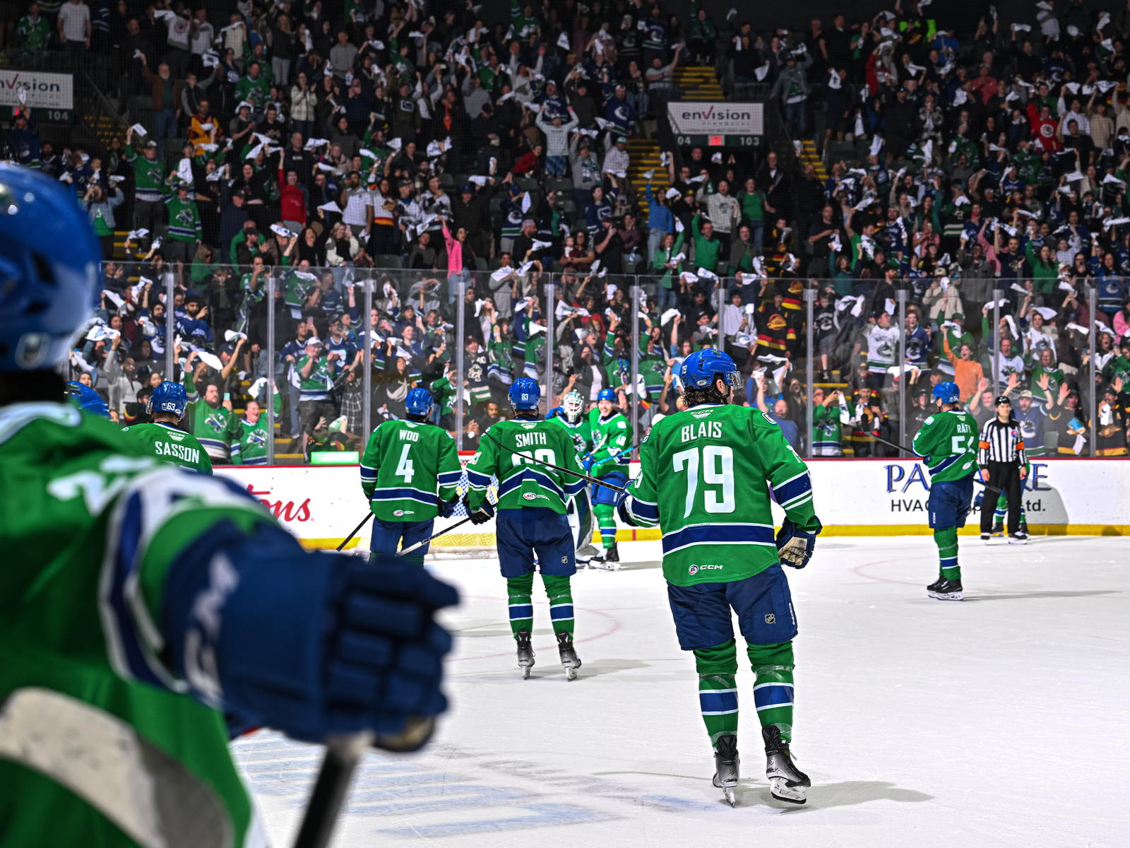 Abbotsford Canucks Sammy Blais (79), Nate Smith (83), Jett Woo (4), and more skate towards celebrating teammates. (Photo by @abbycanucks/X)