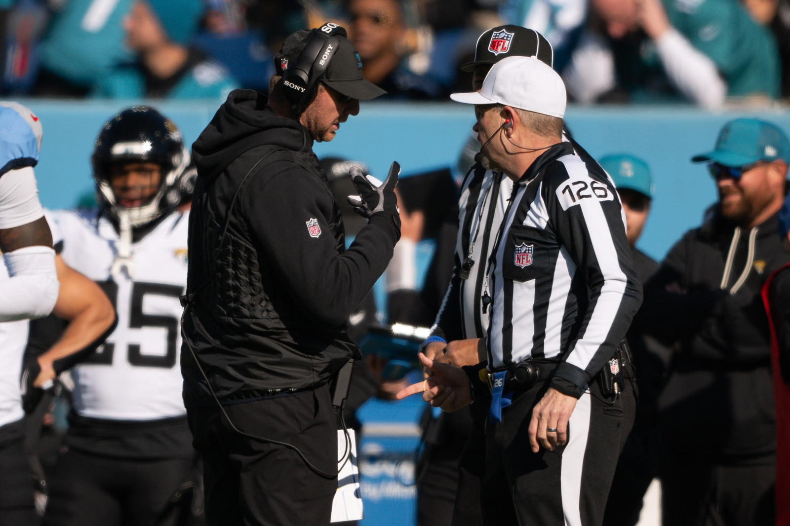 Nov 30, 2025; Nashville, Tennessee, USA; Jacksonville Jaguars head coach Liam Coen talks with side judge Chad Hill (125) after throwing the red flag against the Tennessee Titans during the first half at Nissan Stadium. Mandatory Credit: Steve Roberts-Imagn Images