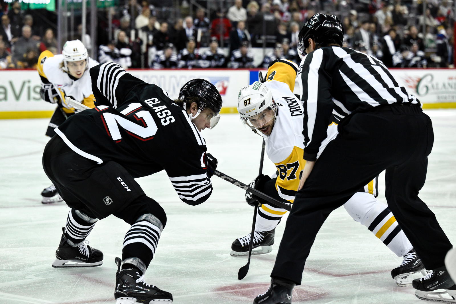 Apr 11, 2025; Newark, New Jersey, USA; New Jersey Devils center Cody Glass (12) faces off against Pittsburgh Penguins center Sidney Crosby (87) during the first period at Prudential Center. (John Jones-Imagn Images)