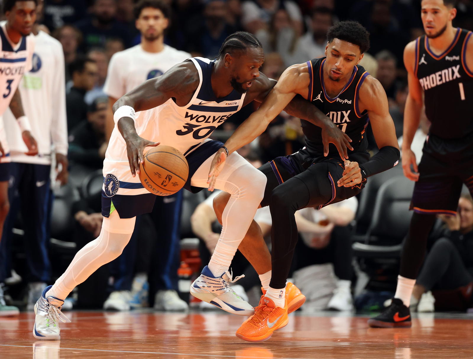 Minnesota Timberwolves forward Julius Randle (30) moves the ball against Phoenix Suns forward Ryan Dunn (0) in the second half of an NBA Cup game at Mortgage Matchup Center.