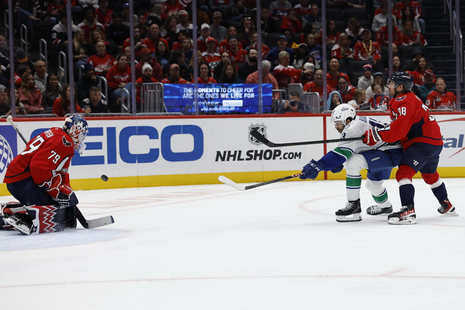Oct 19, 2025; Washington, District of Columbia, USA; Washington Capitals goaltender Charlie Lindgren (79) makes a save against on Vancouver Canucks left wing Arshdeep Bains (13) as Capitals defenseman Rasmus Sandin (38) chases during the second period at Capital One Arena. Mandatory Credit: Geoff Burke-Imagn Images