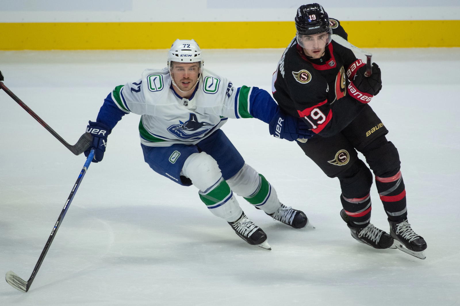 Nov 9, 2023; Ottawa, Ontario, CAN; Vancouver Canucks left wing Anthony Beauvillier (72) and Ottawa Senators right wing Drake Batherson (19) chase the puck in the third period at the Canadian Tire Centre. Mandatory Credit: Marc DesRosiers-Imagn Images