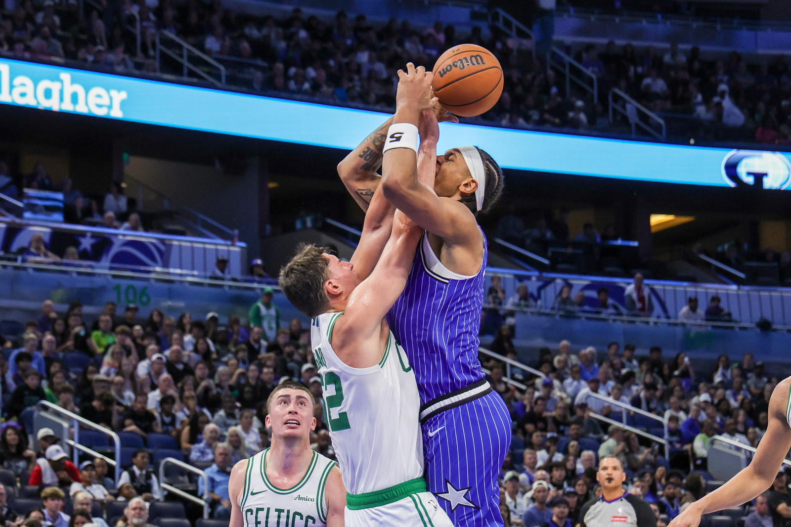 Nov 9, 2025; Orlando, Florida, USA; Orlando Magic forward Paolo Banchero (5) is fouled by Boston Celtics center Luka Garza (52) during the second half at Kia Center. (Mike Watters/Imagn Images)