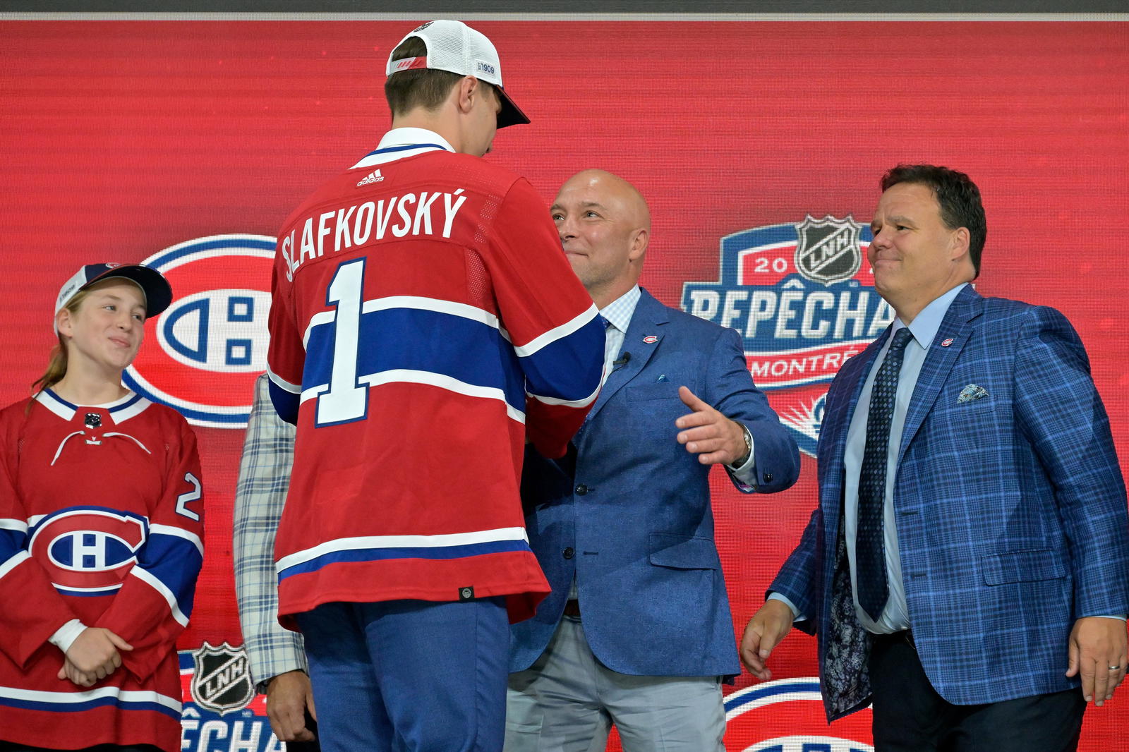 Juraj Slafkovsky shakes hands with Kent Hughes and Jeff Gorton at the 2022 NHL draft. (Eric Bolte-Imagn Images)