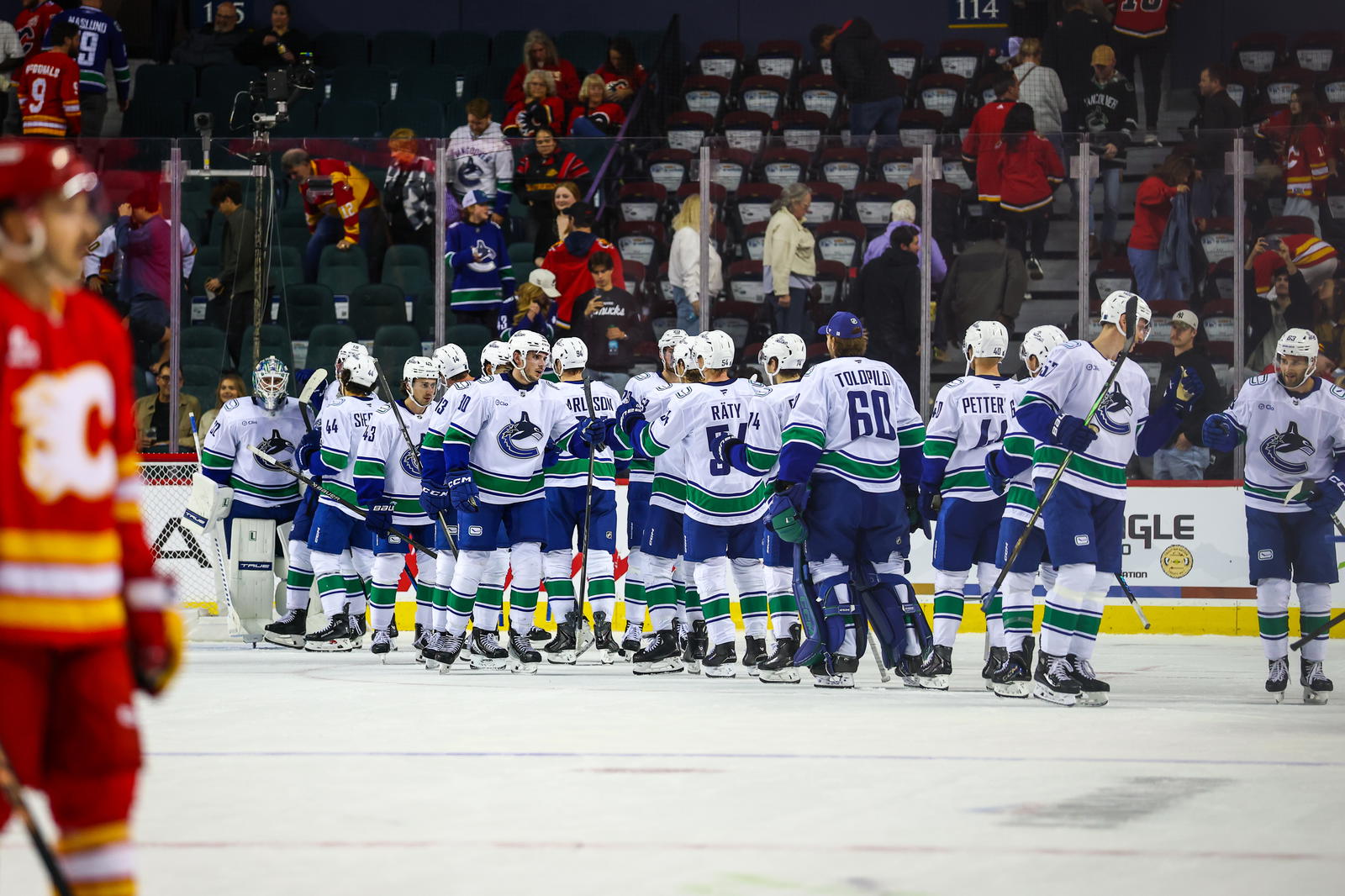 Oct 1, 2025; Calgary, Alberta, CAN; Vancouver Canucks celebrate win over the Calgary Flames at Scotiabank Saddledome. Mandatory Credit: Sergei Belski-Imagn Images