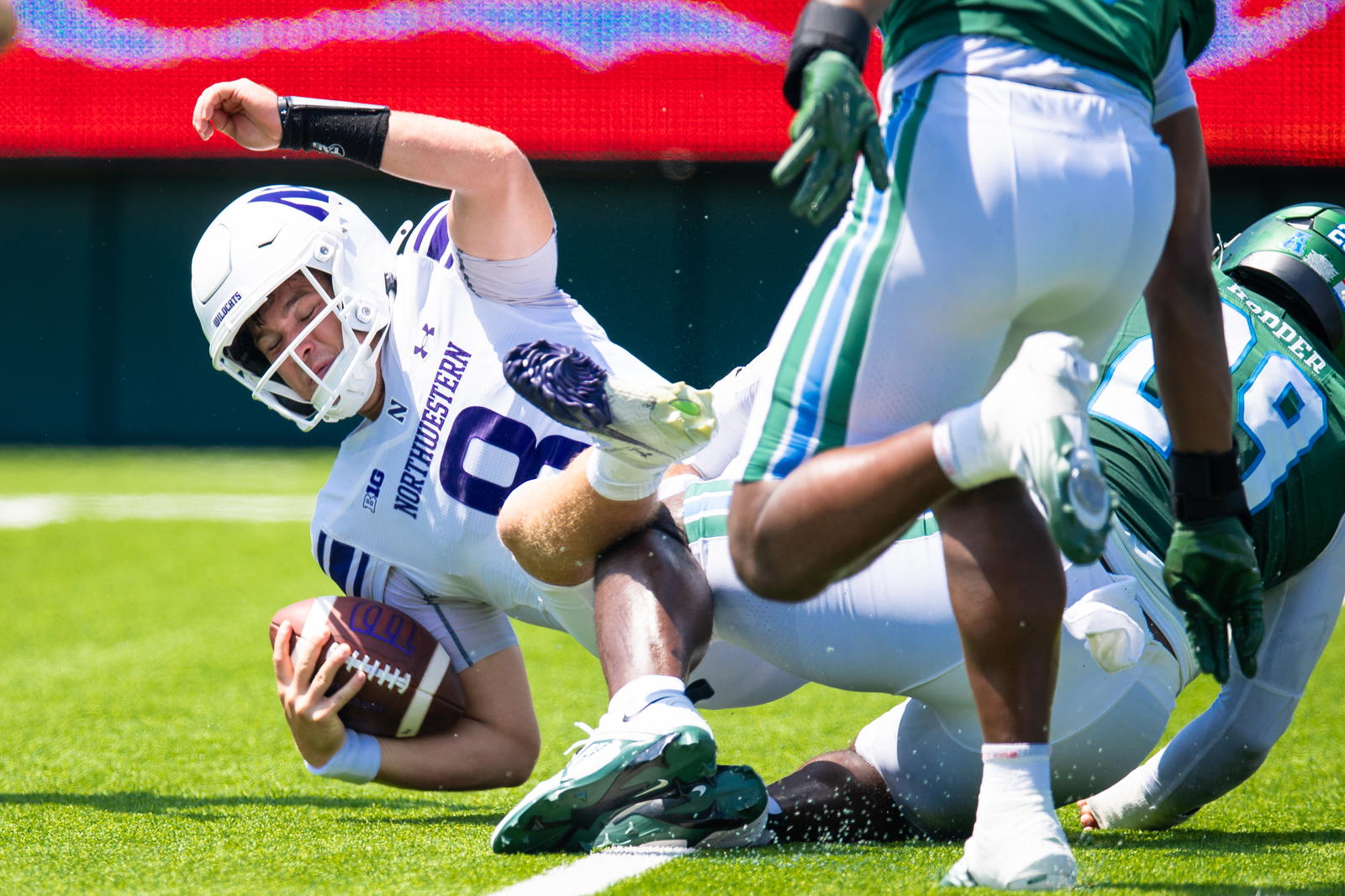 Aug 30, 2025; New Orleans, Louisiana, USA; Northwestern Wildcats quarterback Preston Stone (8) has to scramble out the pocket but is sacked by Tulane Green Wave defensive lineman Santana Hopper (29) during the second half at Yulman Stadium. Mandatory Credit: Stephen Lew-Imagn Images