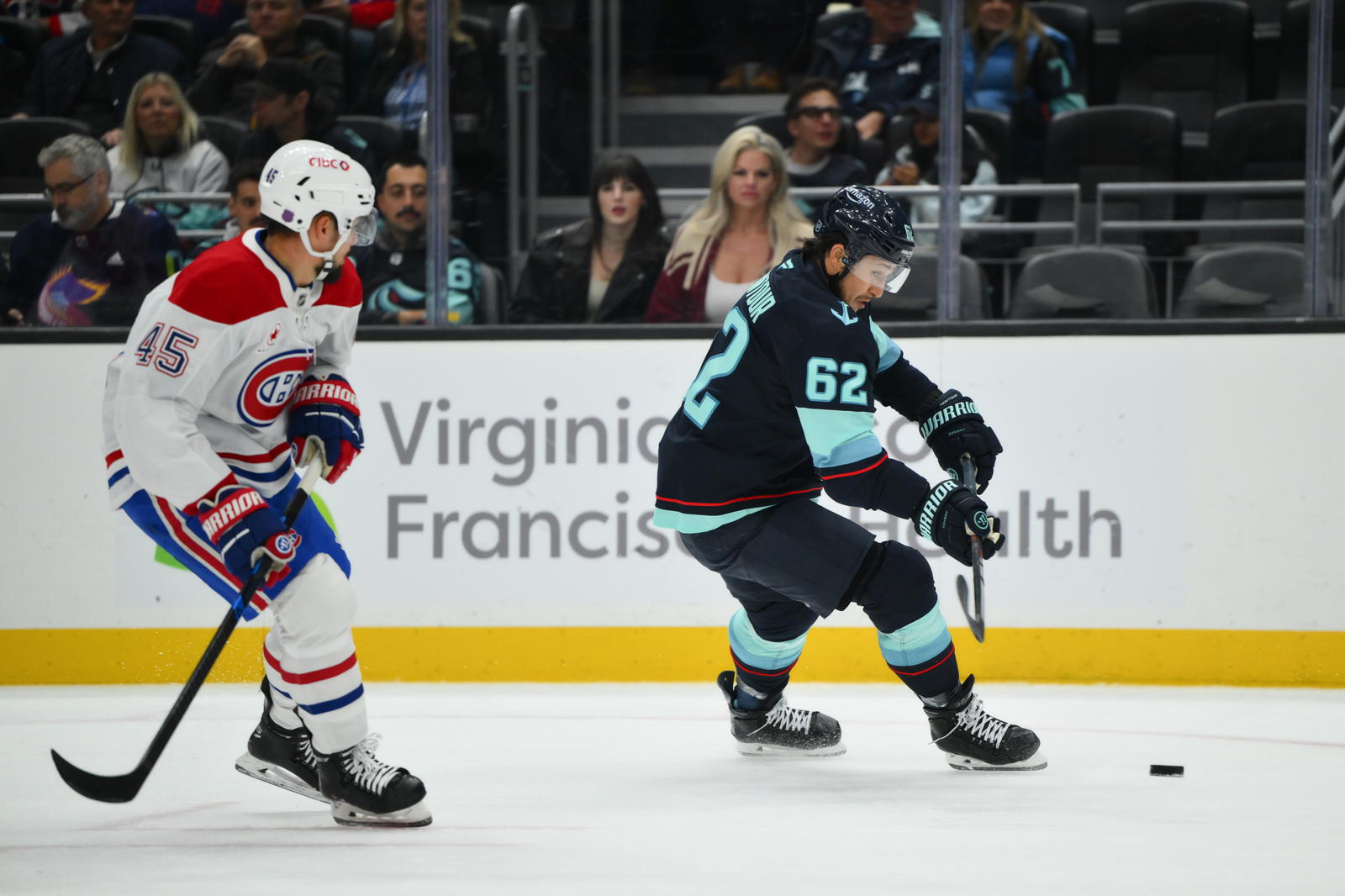 Oct 28, 2025; Seattle, Washington, USA; Seattle Kraken defenseman Brandon Montour (62) passes the puck while defended by Montreal Canadiens defenseman Alexandre Carrier (45) during the first period at Climate Pledge Arena. Mandatory Credit: Steven Bisig-Imagn Images