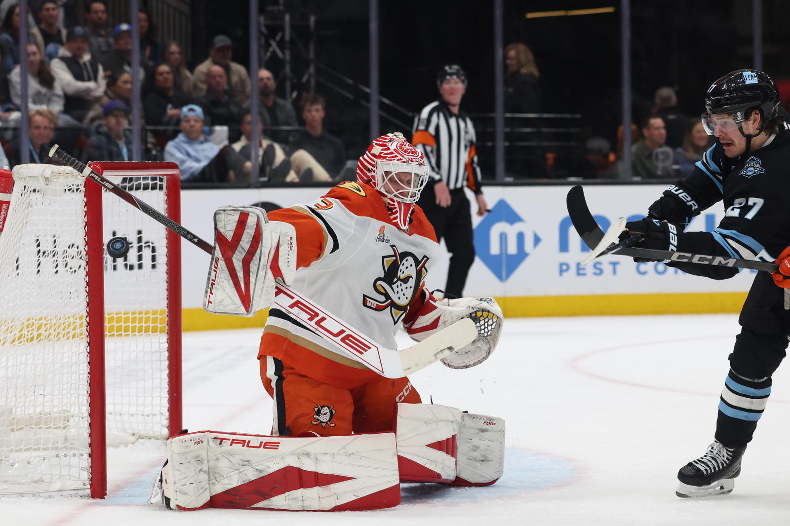 Mar 12, 2025; Salt Lake City, Utah, USA; Anaheim Ducks goaltender Ville Husso (33) blocks a shot as Utah Hockey Club center Barrett Hayton (27) waits for a play during the second period at Delta Center. Mandatory Credit: Rob Gray-Imagn Images