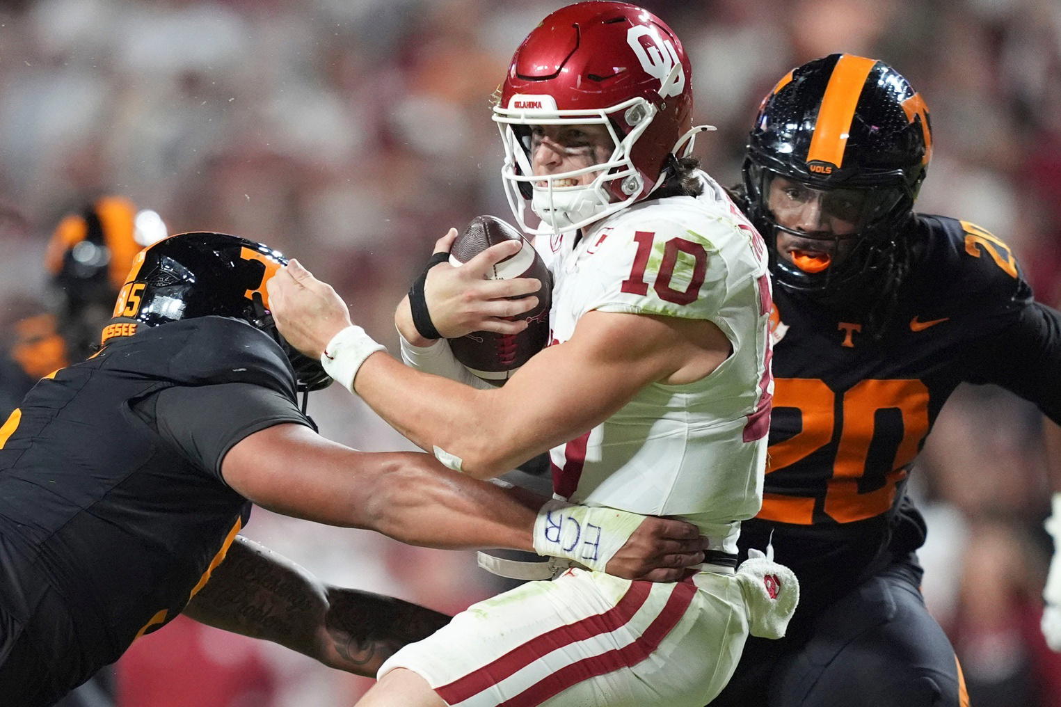 Oklahoma quarterback John Mateer (10) is tackled by Tennessee defensive back Christian Harrison (5) and defensive lineman Bryson Eason (20) during an NCAA college football game on November 1, 2025, in Knoxville, Tenn. (ANGELINE ALCANTAR/Imagn Images)
