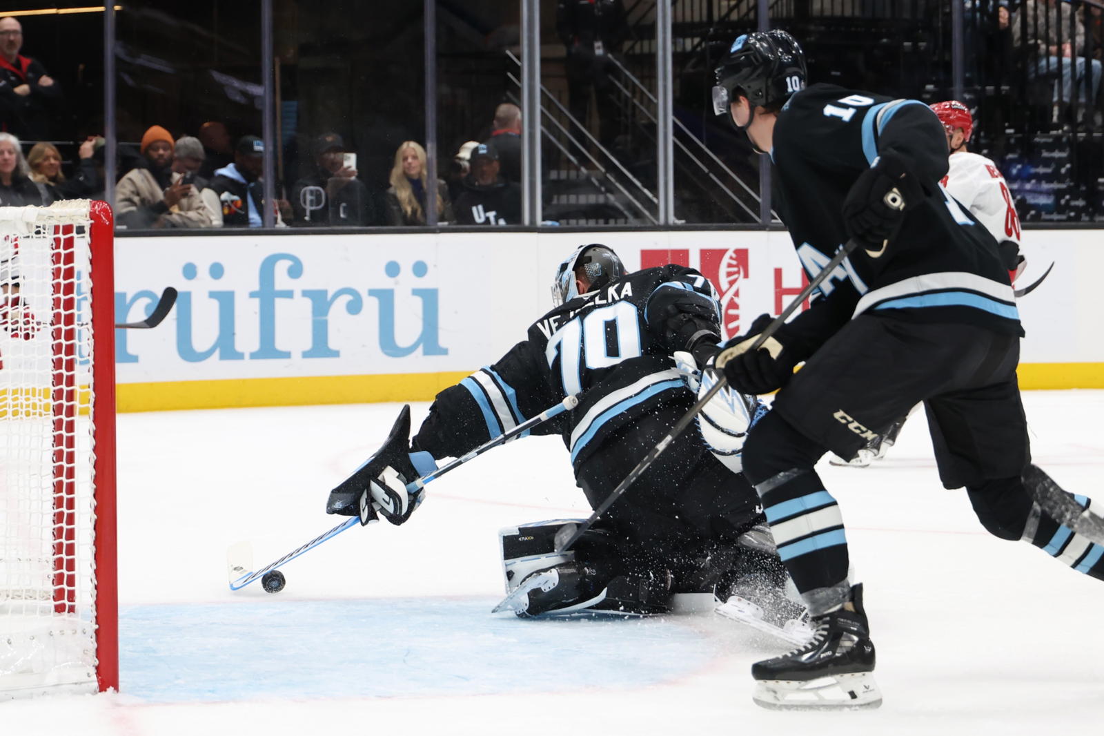 Nov 13, 2024; Salt Lake City, Utah, USA; Utah Hockey Club goaltender Karel Vejmelka (70) reaches back to make a save against the Carolina Hurricanes during the first period at Delta Center. Mandatory Credit: Rob Gray-Imagn Images